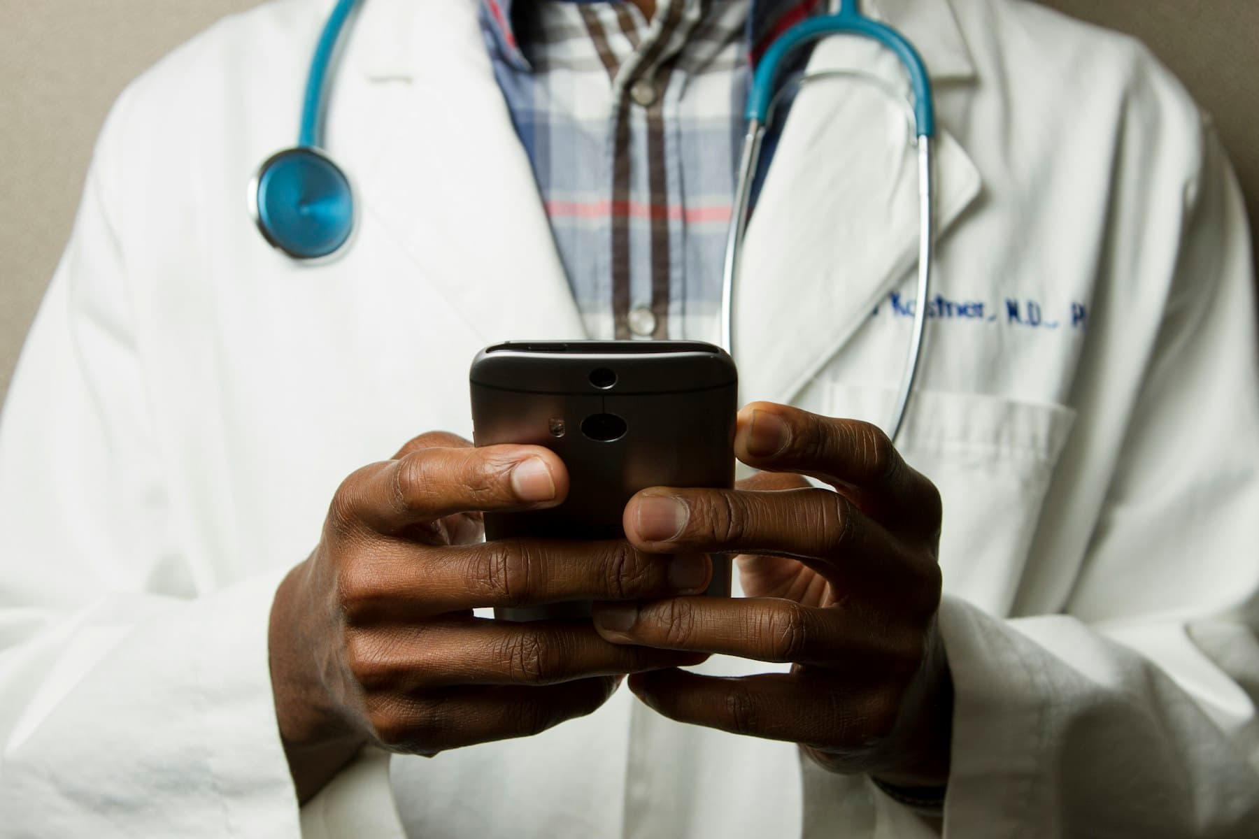 A doctor checks a smartphone between appointments
