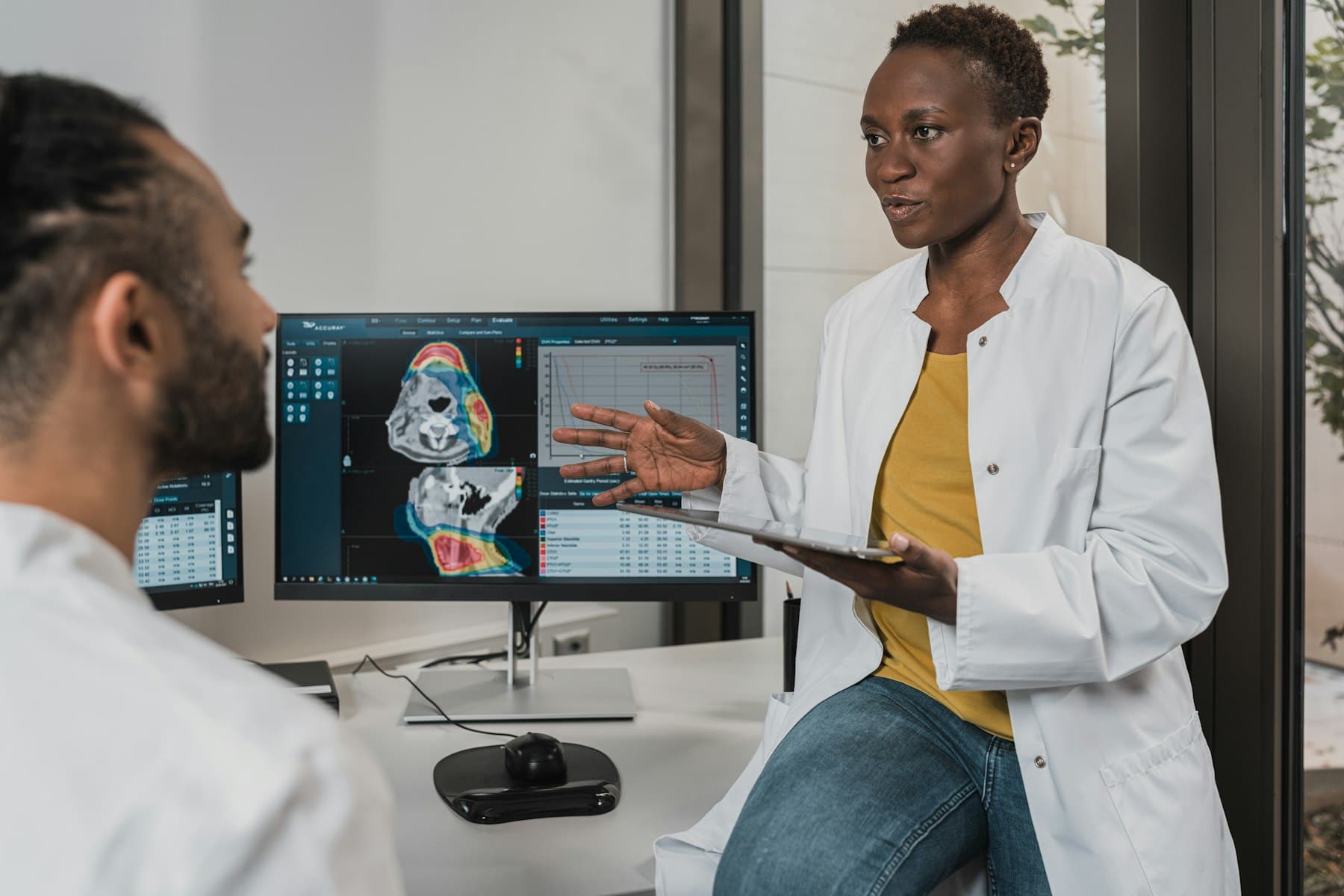 A doctor walks a patient through scan results on a monitor